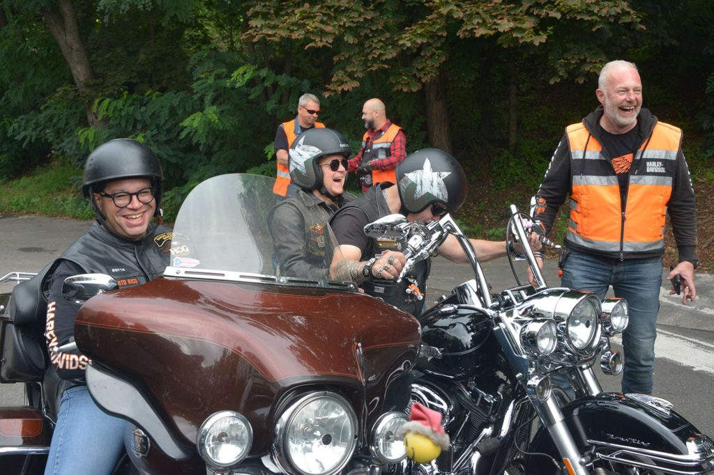 A picture of some people on motorcycles in a forest.