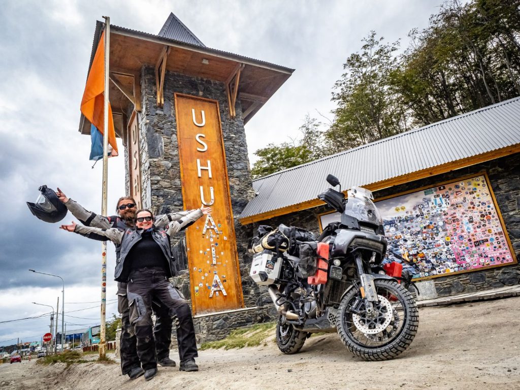 Ela and Greg Kedzior standing together next to a motorcycle.