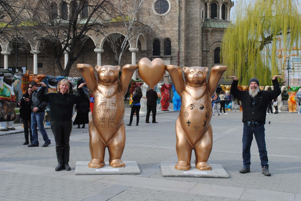 A picture of Bob and Chris posing with a bear statue in Bulgaria.