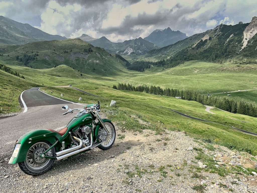 A picture of a green motorcycle with mountains in the background.