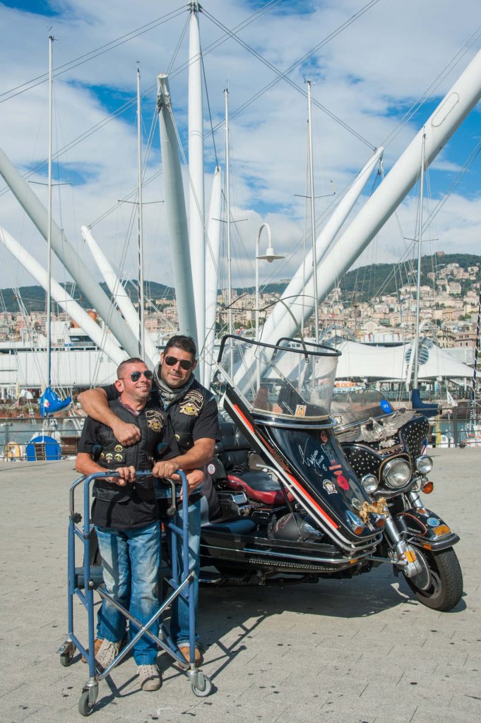 H.O.G. members standing with a Harley-Davidson motorcycle.