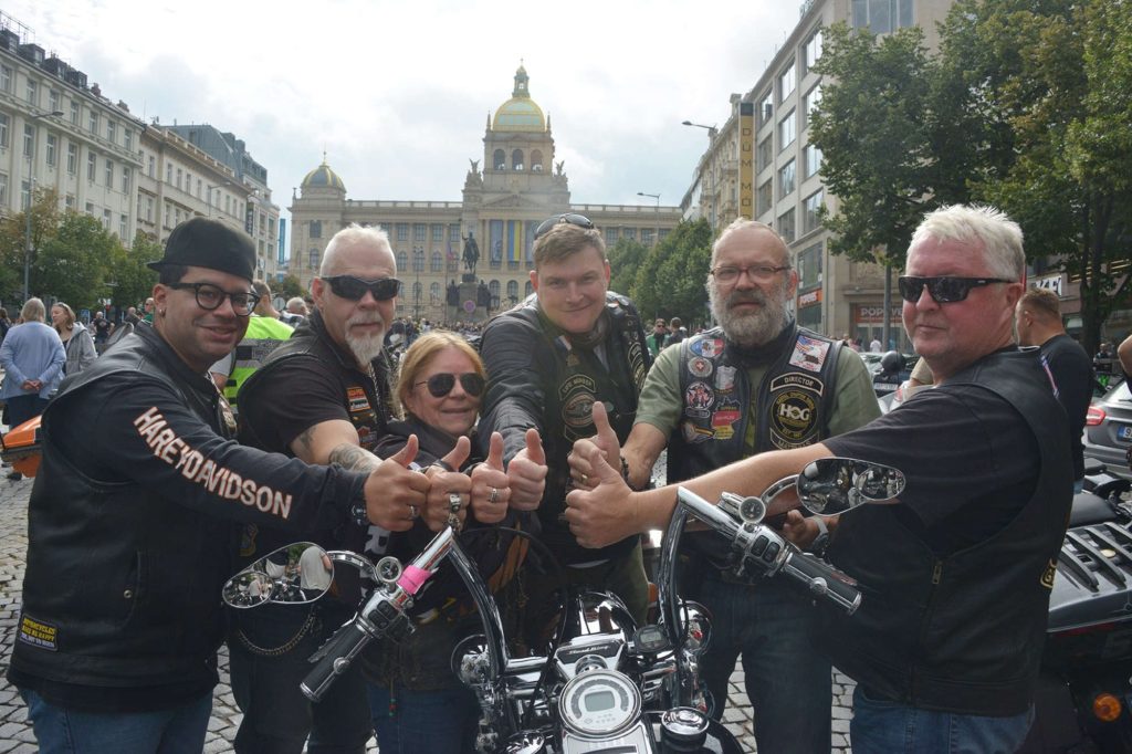 H.O.G. members posing with a motorcycle.