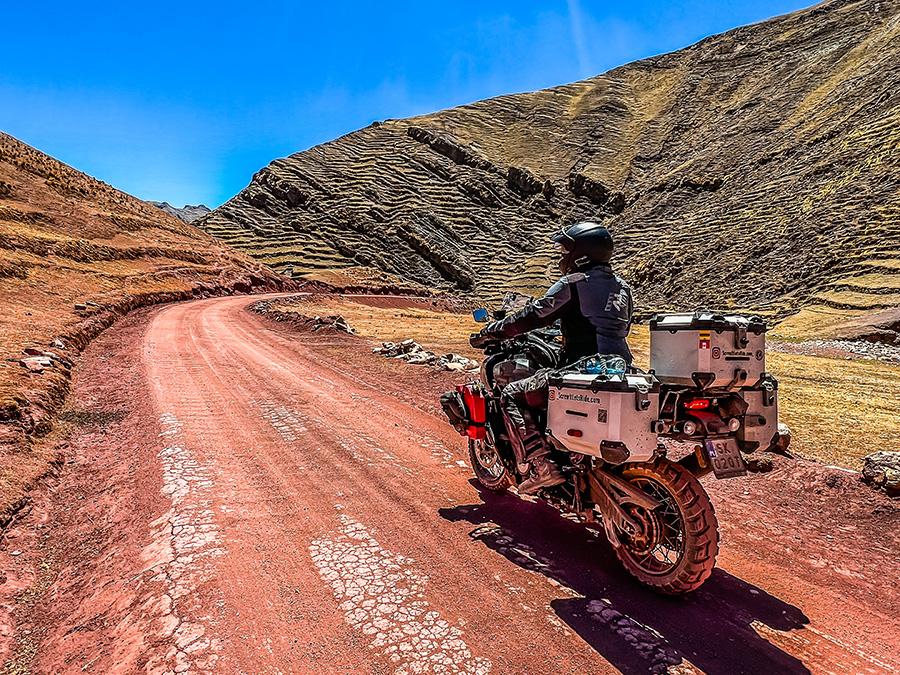 Biker riding on red sands in the hills