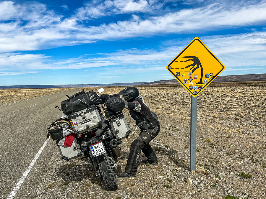 Ela picking bike up next to strong winds warning sign