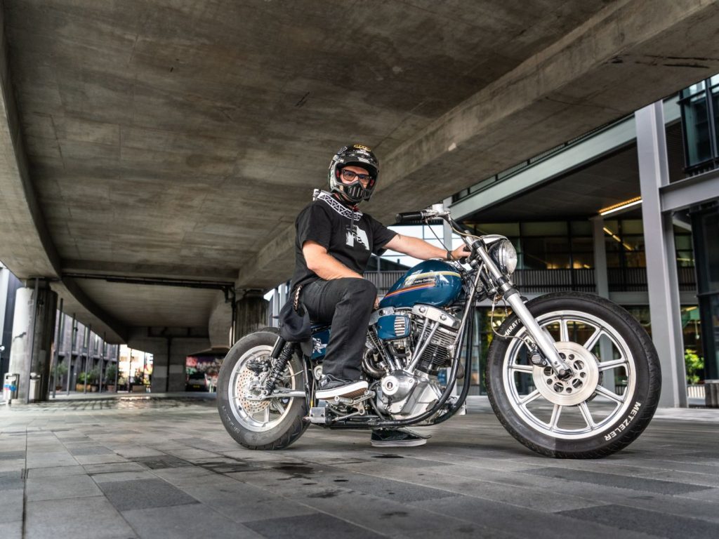 Adam Brinkworth sitting on his custom Harley-Davidson.