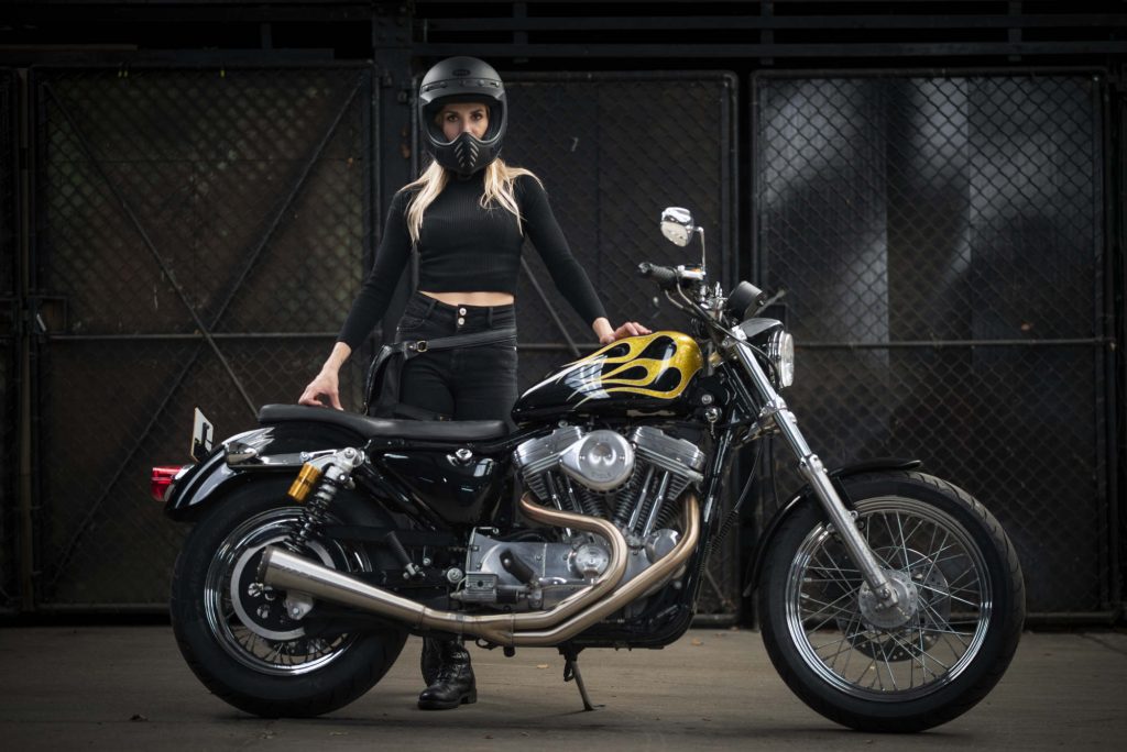Laura standing with her Harley-Davidson.
