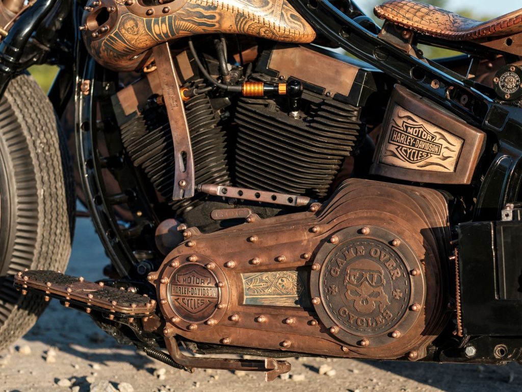 A close-up of tattooed leatherwork on a Harley-Davidson.