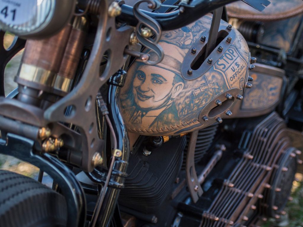 Tattooed illustrations on the leatherwork of a Harley-Davidson.